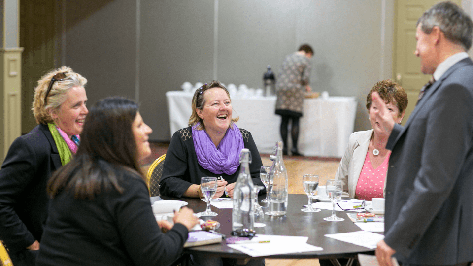 Group of people sitting round a table at a business networking event