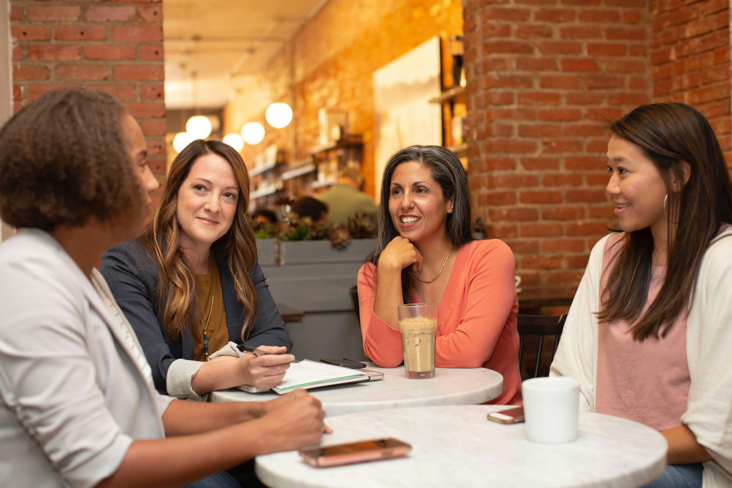 Group of professional people sat round a table having a friendly meeting